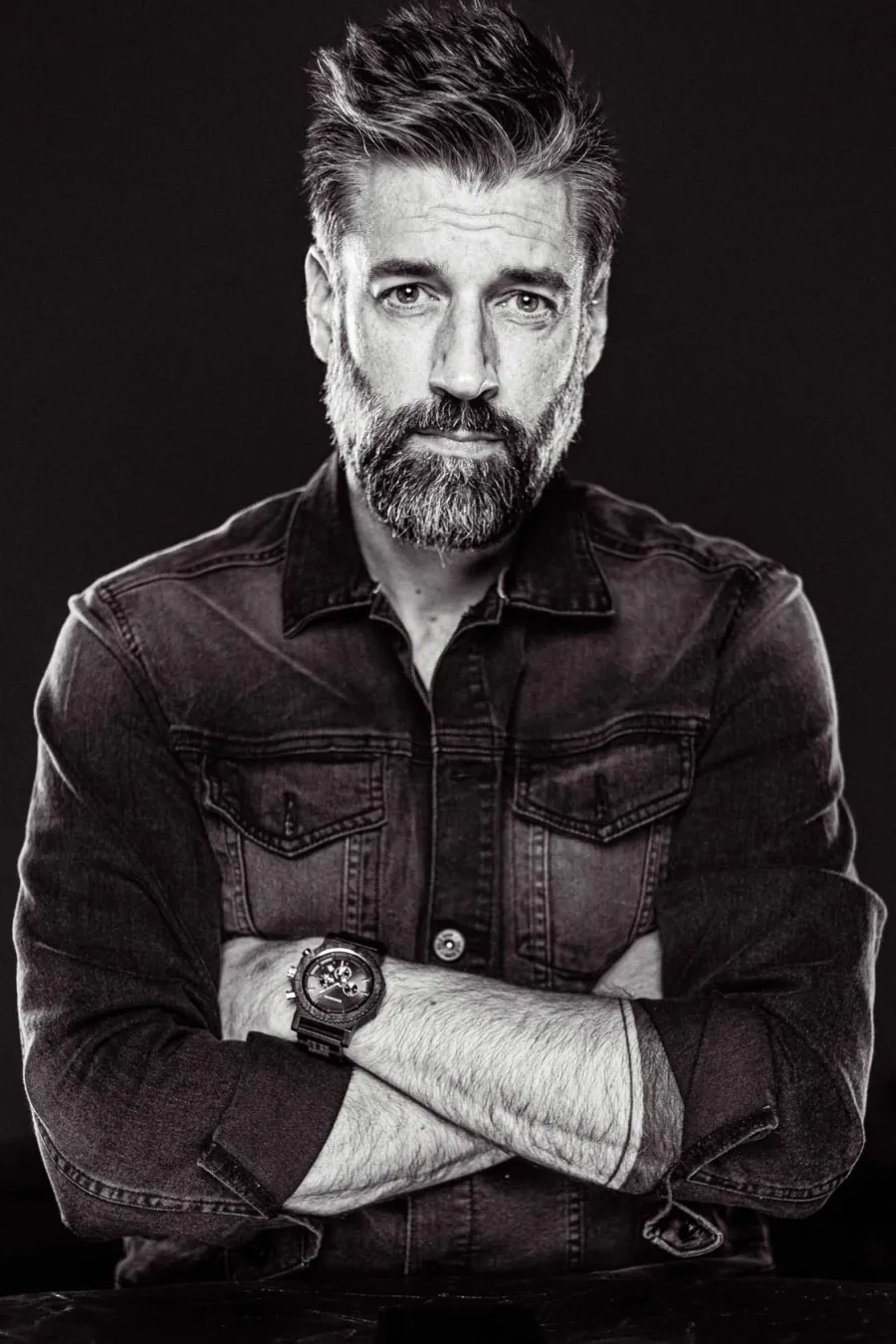 Portrait en noir et blanc d'Alexandre Comtois, bras croisés, en chemise de jean